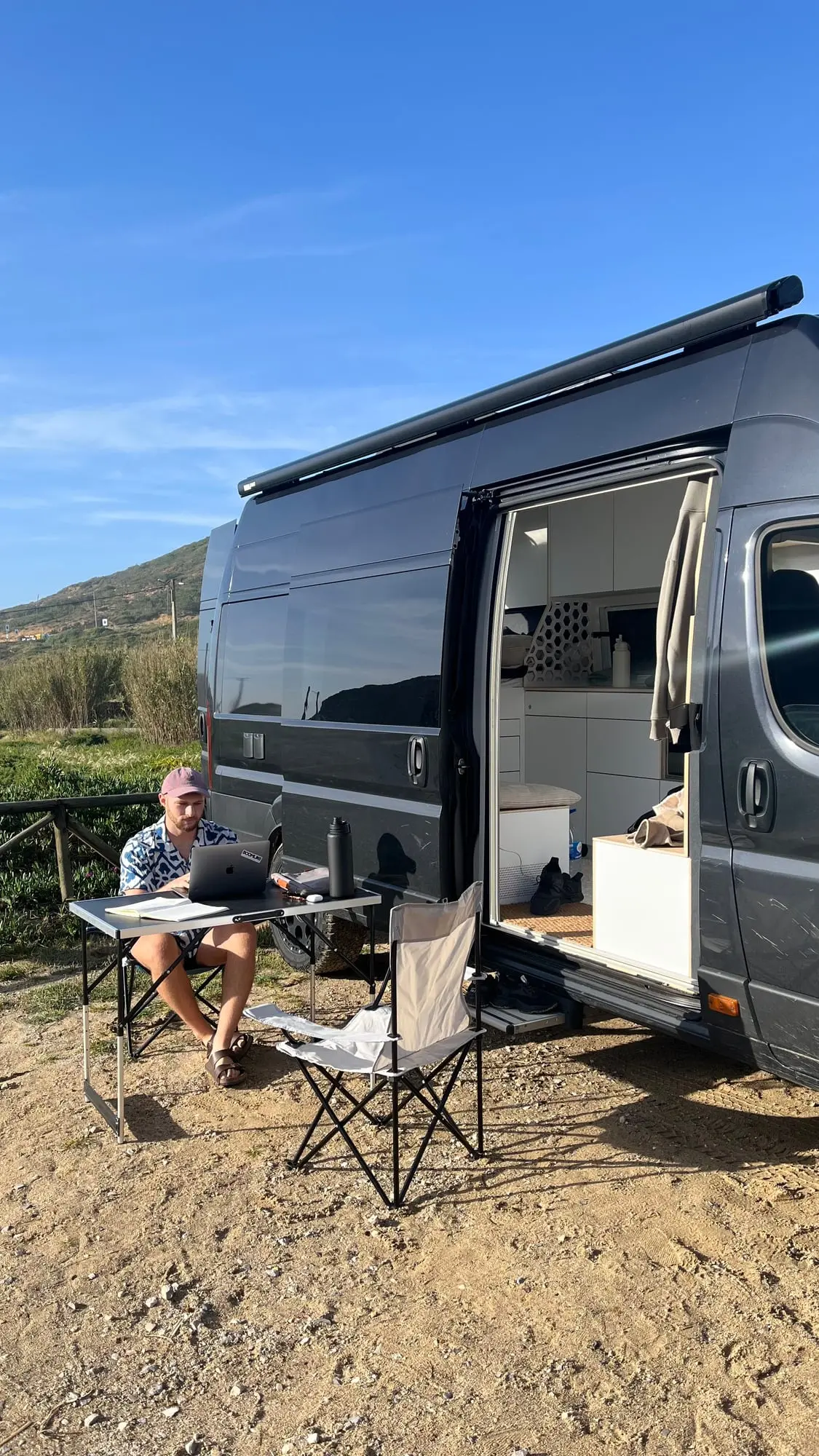 Arbeiten am Laptop vor einem Campervan