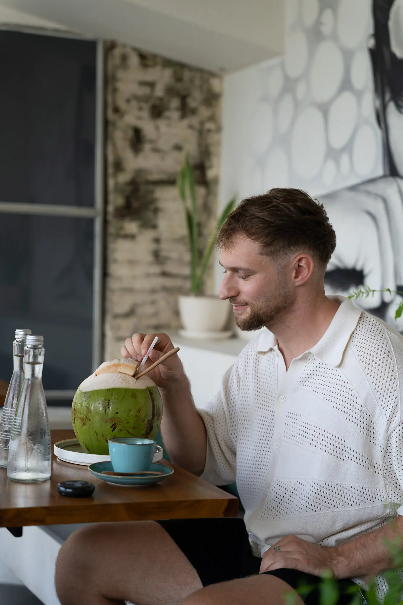 Tim mit frischer Kokosnuss im Café