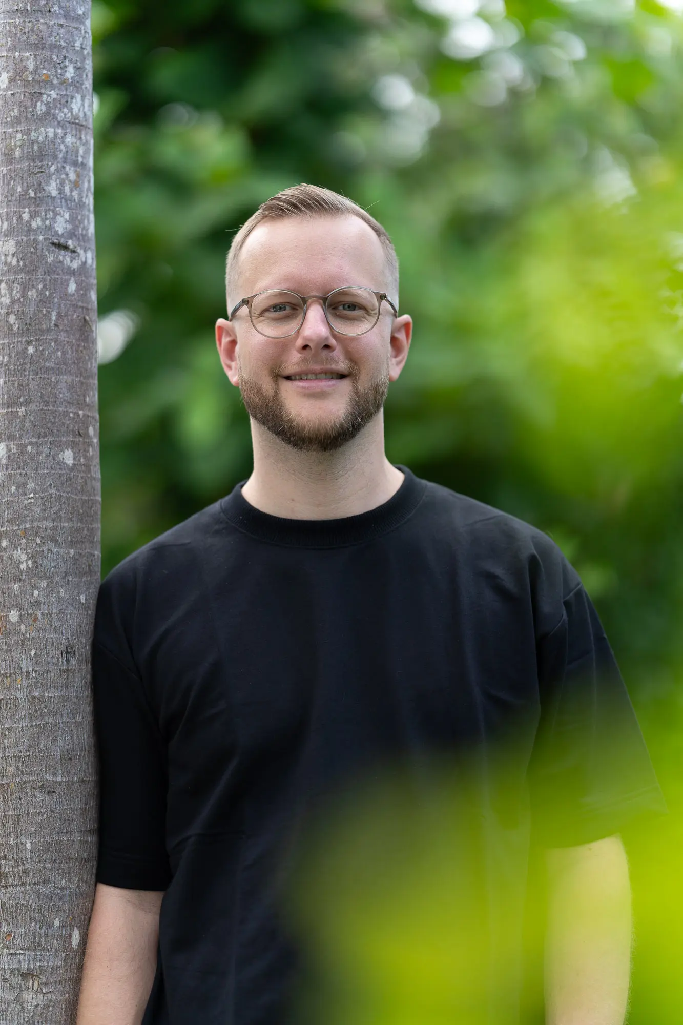 Tim lächelt an einer Palme auf Bali