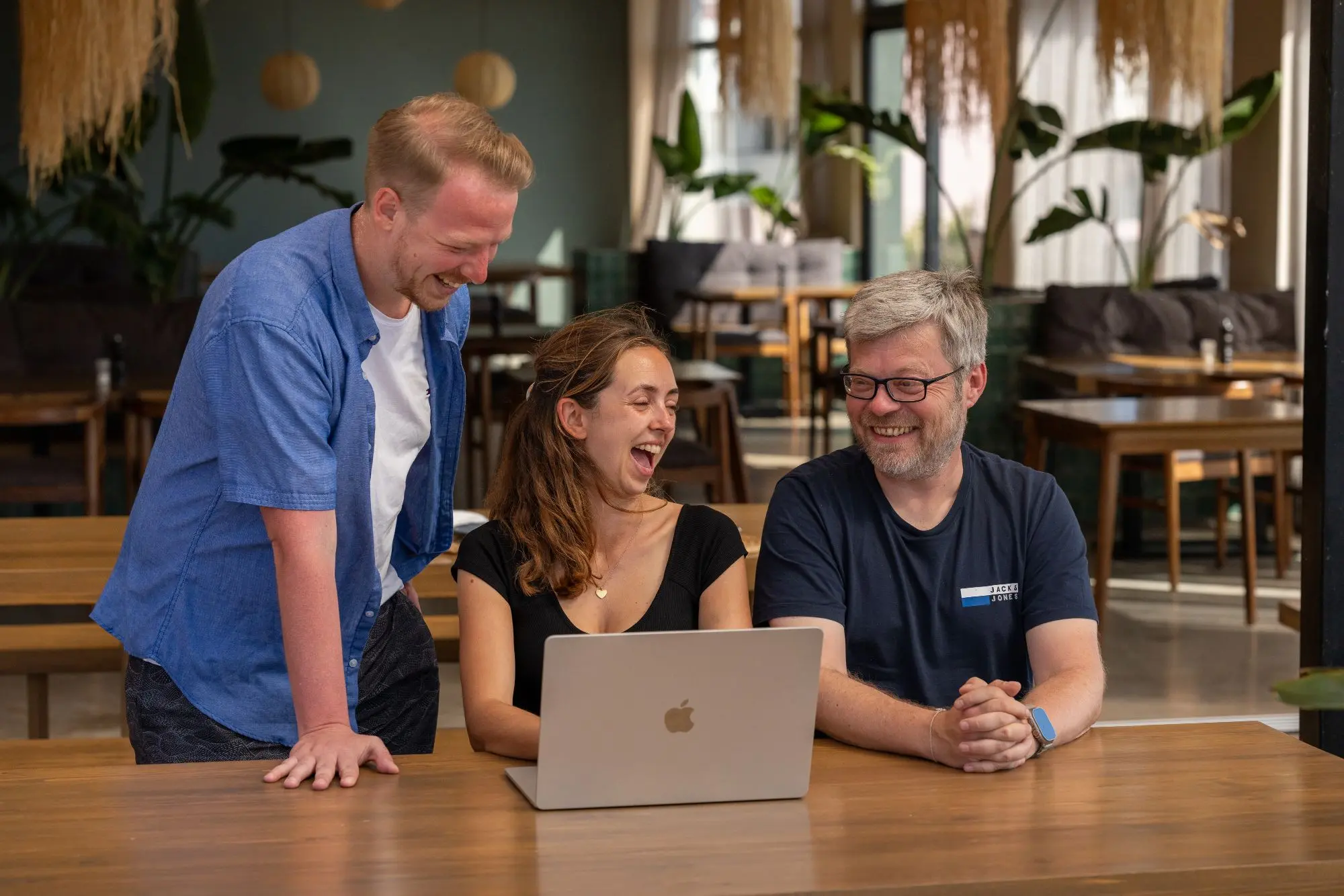 Manuel lacht mit anderen Teilnehmern am Laptop