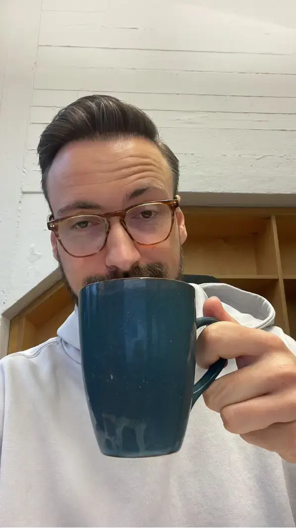 Enrico früher mit Kaffeetasse am Schreibtisch