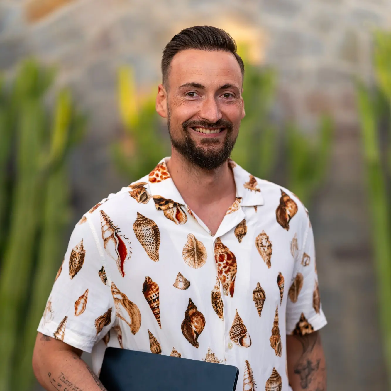 Enrico heute, lächelnd mit Laptop unter dem Arm auf Teneriffa